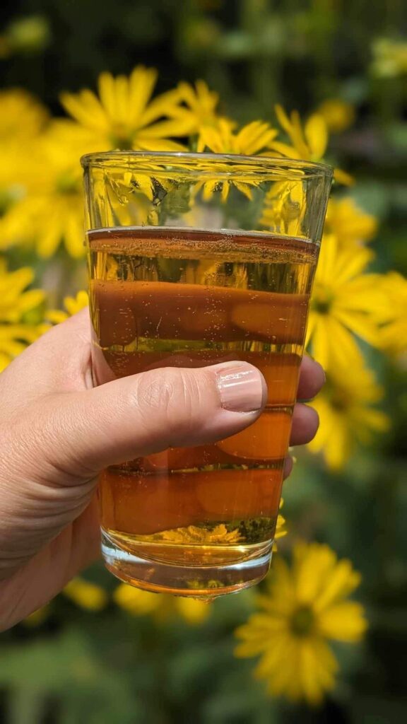 glass of beer against a yellow flower background